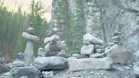 A-collection-of-several-Man-Made-Rock-Inuksuit-Statues-in-a-Dried-Up-River-Bed-in-the-Bright-Sun