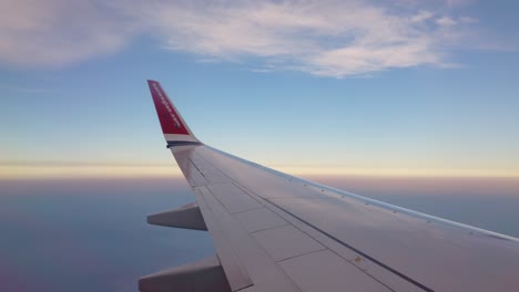 POV-Aus-Dem-Fenster-Neben-Dem-Flügel-Eines-Norwegischen-Flugzeugs-Hoch-Im-Blauen-Bewölkten-Himmel