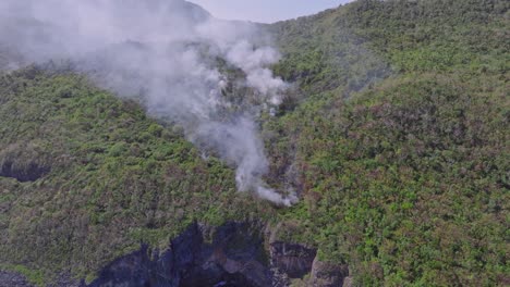 Fire-smoke-in-forest-of-Cabo-Cabron-National-Park-along-cliffs-of-coast,-Samana-in-Dominican-Republic