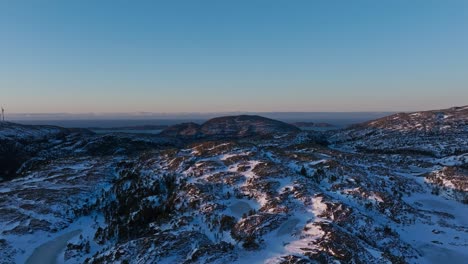 Mountains-And-Forests-Covered-In-Snow-In-Bessaker,-Norway-At-Sunset---Drone-Shot