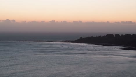 Toma-Estacionaria-De-Drones-De-Las-Olas-Golpeando-La-Playa-En-El-Océano-Pacífico.