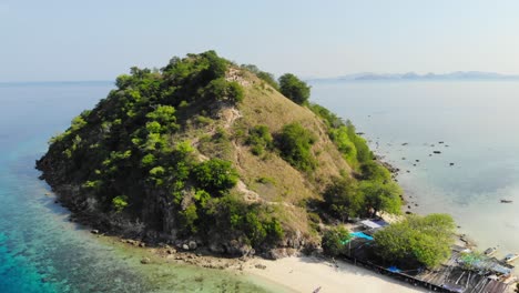 Beautiful-aerial-shot-of-Pulau-Kelor-Komodo,-drone-flying-backward-to-reveal-the-entire-island,-showcasing-its-stunning-landscape