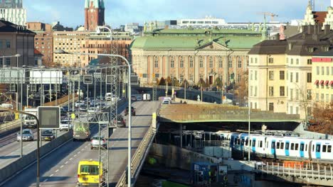 Subway-train-and-car-traffic-on-bridge-in-sunny-Stockholm,-Sweden