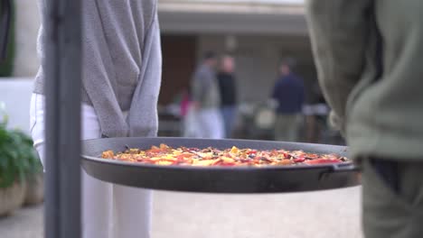 Llevando-Paella-A-Una-Reunión-De-Gente-Celebrando