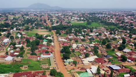 Red-dirt-roads-in-a-rural-suburb-of-Gboko-Town,-Nigeria-west-Africa---rising-aerial-view