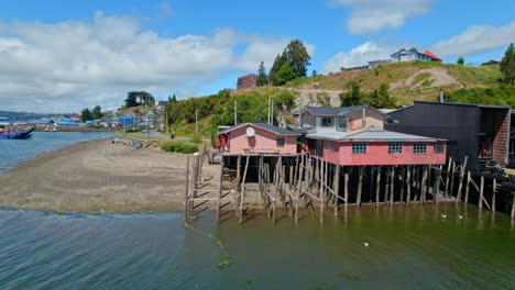 Drone-Flyover-Colorful-Traditional-Stilt-Houses-In-Castro,-Chiloe-4K