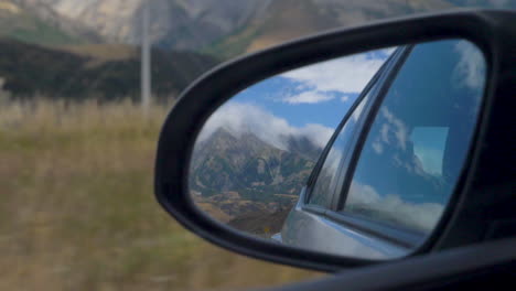 Slow-Motion-shot-of-a-mountain-in-a-car-wing-mirror---Arthur's-Pass,-New-Zealand