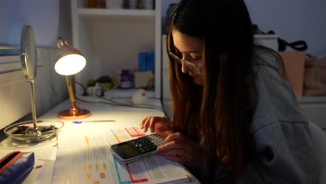Mädchen-Mit-Brille-Studiert-Nachts-Das-Ausführen-Von-Operationen-Mit-Einem-Wissenschaftlichen-Taschenrechner