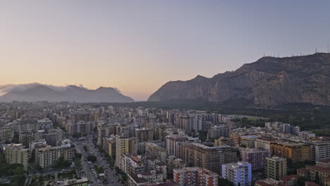 Palermo,-Italien,-Luftaufnahme-V2,-Drohne-Schwenkt-über-Die-Straße-Viale-Campania-Und-Nimmt-Panoramablicke-Auf-Die-Stadtlandschaft-Und-Die-Bergketten-Auf,-Mit-Vögeln,-Die-über-Den-Sonnenuntergangshimmel-Fliegen-–-Aufgenommen-Mit-Mavic-3-Cine-–-Mai-2023