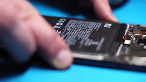 Replacing-Battery-in-Smartphone-During-Repair,-Close-Up