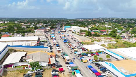 Panoramic-aerial-overview-above-parked-cars-and-tent-shades-along-street-for-Carnaval-Grand-March-Curacao