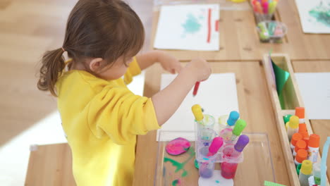 Glückliches-Mädchen-Macht-Die-Ersten-Tropfen-Wasserfarbe-Auf-Papier