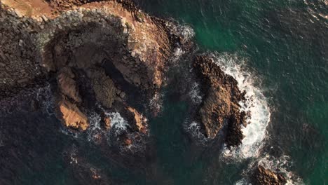 Japanese-beach-cliff-landscape,-aerial-drone-waves-breaking-by-shore-in-japan-kyoto-kyotango-beach,-travel-destination-in-summer,-asian-sunshine-top-down-view