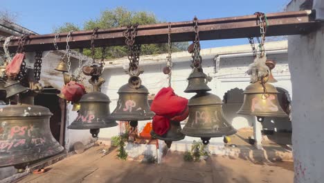 Amplia-Toma-De-Campanas-Religiosas-Colgadas-Dentro-De-Un-Antiguo-Templo-De-Tradición-Hindú-En-Madhya-Pradesh,-India.