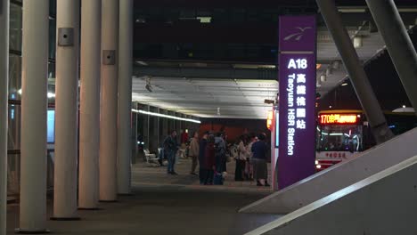 Menschen-Warten-Auf-Den-Anschlussbus-Und-Reisende-Betreten-Das-Gebäude-Des-Hochgeschwindigkeitsbahnhofs-A18-In-Taoyuan,-Handkameraaufnahme-Am-Eingang,-Reise-Nach-Taiwan