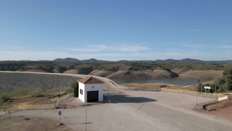 An-aerial-ascent-unveils-the-mountain-cradled-waters-of-the-Embalse-del-Río-Yeguas,-serving-as-a-reservoir-essential-for-irrigation,-flood-management,-and-water-provisioning