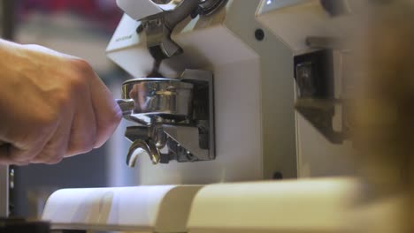 Guy-Pouring-Coffee-Powder-in-a-Filter-Handle-With-a-Very-Fancy-Machine-in-a-Coffee-Shop