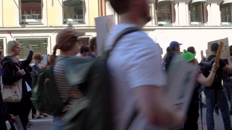 Climate-protest-march-with-signs-and-megaphone-in-Stockholm,-side-view