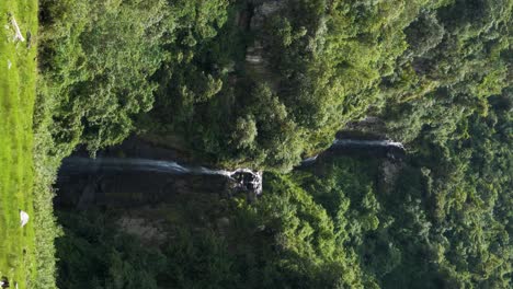Vertical-clip-of-a-beautiful-large-waterfall-in-the-neighborhood-of-Puichig,-Mejia-canton,-province-of-Pichincha,-Ecuador
