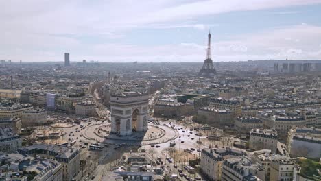 Triumphal-arch-or-Arc-de-Triomphe-with-Tour-Eiffel-and-Montparnasse-tower-in-background,-Paris-cityscape,-France