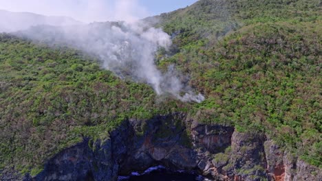 Fire-smoke-in-forest-of-Cabo-Cabron-National-Park-along-high-cliffs,-Samana-in-Dominican-Republic