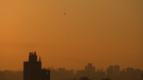 Building-in-São-Paulo-at-dawn-in-spring,-orange-sun-with-baloons-4k-long-lens-tele