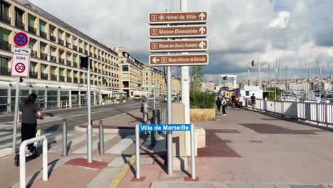 Static-view-of-Ville-de-Marseille-sign-and-people-by-sunny-old-port