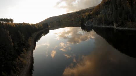 Cinematic-aerial-wide-shot-of-a-calm-lake-at-sunset