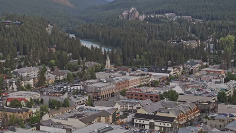 Banff-AB-Canada-Aerial-v7-zoomed-drone-flyover-town-capturing-picturesque-townscape,-quaint-streets-lined-with-shops-and-restaurants-surrounded-by-lush-forests---Shot-with-Mavic-3-Pro-Cine---July-2023