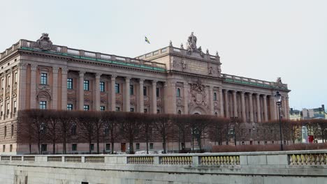 Parliament-building-with-Swedish-flag-in-Stockholm,-wide-static-view