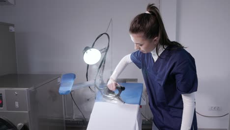 Female-Worker-Ironing-Clothes-At-Laundry-Shop