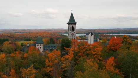 Saint-Benoit-du-Lac-abbey-in-Quebec-province-near-Magog-on-the-shore-of-Memphrémagog-lake-during-autumn-season-with-colorful-trees,-Canada