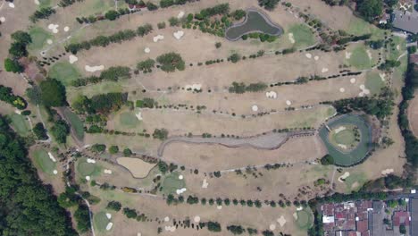 Massive-golf-course-field-in-Indonesia,-aerial-top-down-view