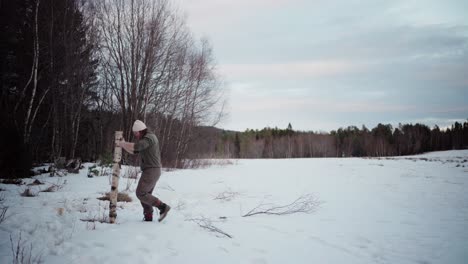 The-Man-is-Transporting-a-Log-for-Use-as-Firewood-in-the-Winter---Static-Shot