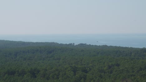 A-panoramic-view-from-the-top-of-the-Stilo-lighthouse,-overlooking-the-lush-green-forest-and-the-Baltic-sea