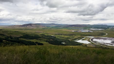 Amplia-Vista-Del-Paisaje-Islandés-Con-Montañas-Y-Cielos-Nublados,-Vegetación-En-Primer-Plano.