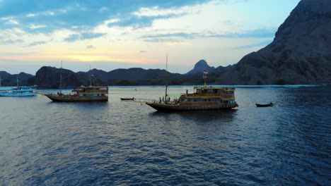 three-cruise-ships-anchored-off-Padar-Island,-near-Komodo-in-Indonesia,-captured-from-a-drone-during-the-evening