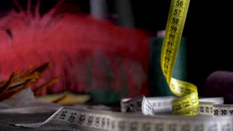 tailor-measure-tape-unroll-in-slow-motion-dolly-black-background-feather
