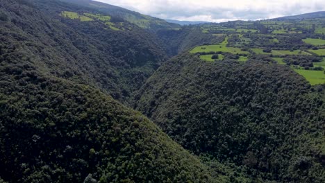 Kinematic-drone-movement-over-a-plant-covered-canyon-and-river-at-Puichig,-Pasochoa-volcano,-Machachi,-Ecuador