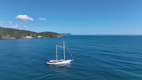 Aerial-circling-sailboat-on-coast-of-Samana-on-sunny-day,-Dominican-Republic
