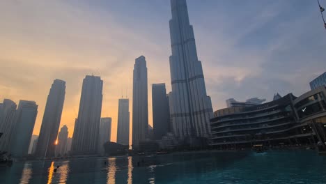 Burj-Khalifa,-Dubai-Lake-Und-Wolkenkratzer-In-Der-Innenstadt-Bei-Sonnenuntergang,-Weite-Aussicht