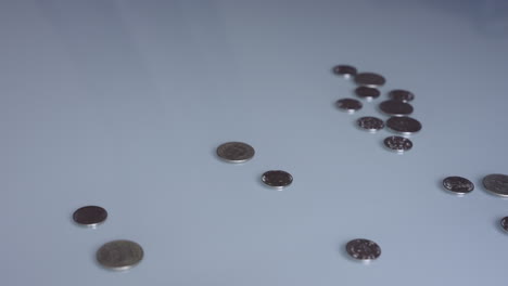 Eine-Hand-Fegt-Münzen-Von-Einem-Tisch