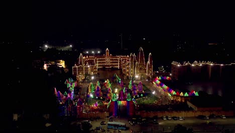 Aerial-drone-view-in-drone-camera-the-temple-is-looking-very-beautiful-with-lights-and-many-people-are-watching-the-lighting-from-outside
