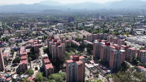 Vuelo-Aéreo-Sobre-Viviendas-En-Coyoacán,-Al-Sur-De-La-Ciudad-De-México,-Con-El-Campus-Universitario-Al-Fondo.