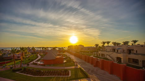 Magníficos-Lapsos-De-Tiempo-Del-Amanecer-En-El-Horizonte-Con-Un-Hotel,-Palmeras-Y-El-Mar-Al-Fondo