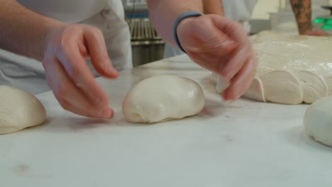Close-up-on-Chef-hands-showcase-the-process-of-balling-pizza-dough