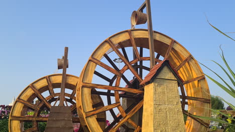 Water-Mills-in-Dubai-Miracle-Garden,-Tourist-Attraction-on-Golden-Hour-Sunlight