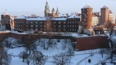 Panorama-of-snow-covered-Wawel-castle-and-Old-Town-at-magic-morning-with-soft-sun-light-during-winter,-Krakow,-Poland