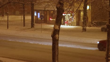 Wide-static-view-of-evening-street-traffic-in-snowy-Stockholm,-Sweden