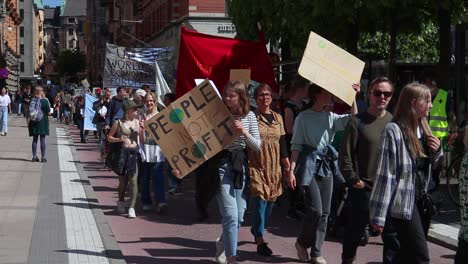 Girl-with-People-Not-Profit-sign-at-climate-march-in-Stockholm,-slomo